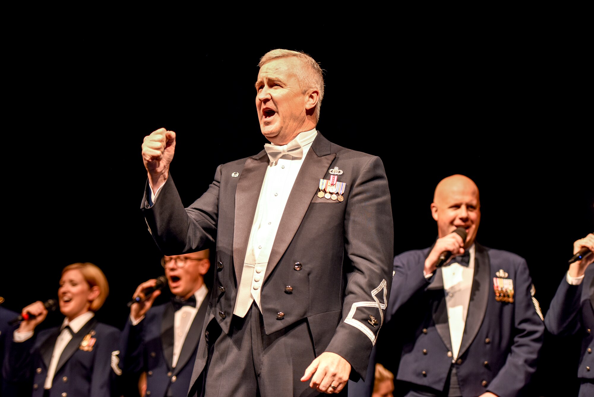 U.S. Air Force Col. Larry Lang, Air Force Band commander, sings, “America the Beautiful” with audience members, the U.S. Air Force Concert Band and Singing Sergeants during a concert  at the Murphey Performance Hall in San Angelo, Texas, Oct. 22, 2018. Lang has commanded the Air Force Band since 2012. (U.S. Air Force photo by Aryn Lockhart/Released)