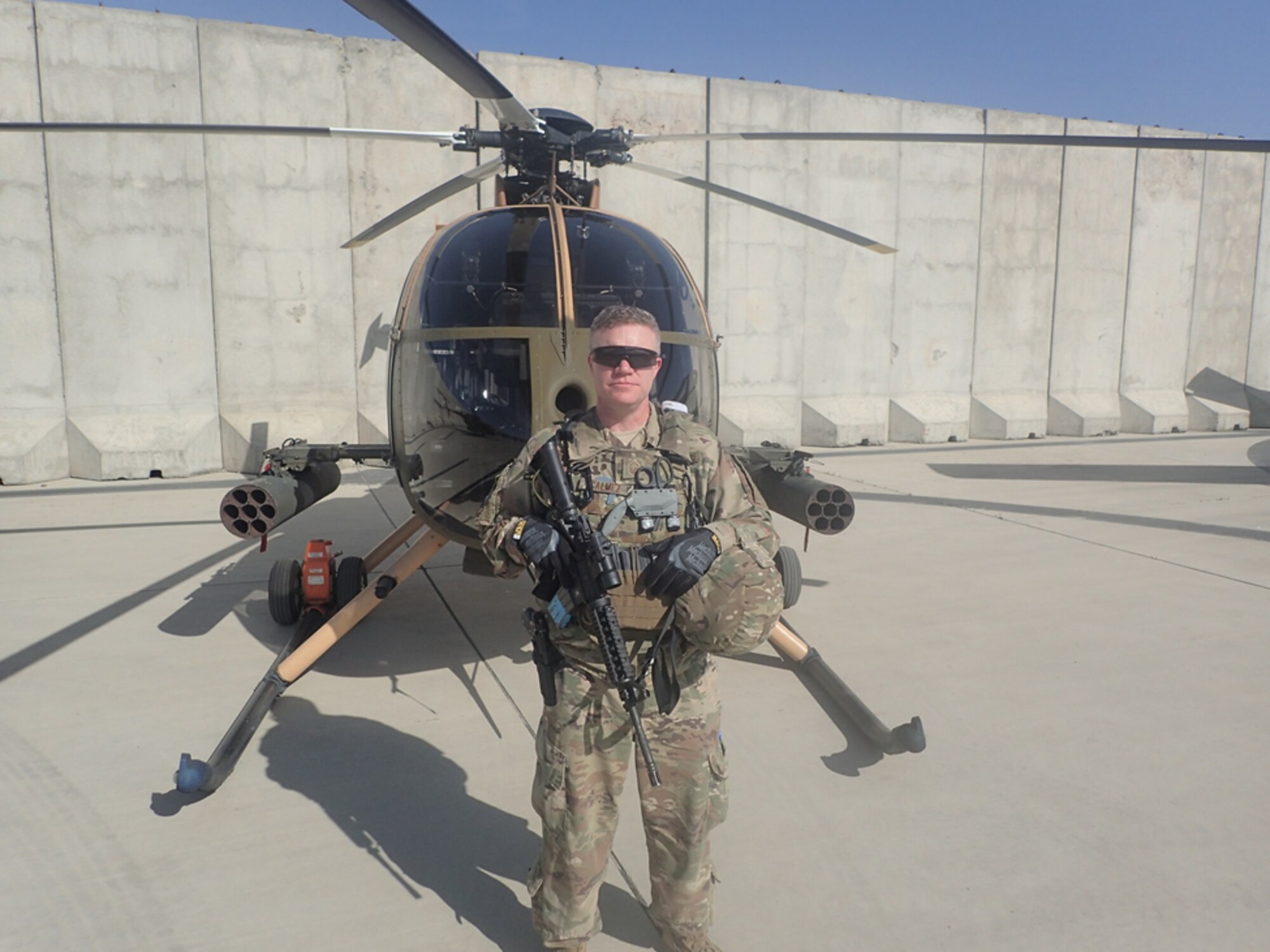 Senior Master Sgt. Travis J. Calmez stands in front of a MD-530 helicopter on Forward Operating Base Oqab, Kabul, Afghanistan May 10, 2018.