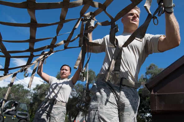 U.S. Air Force Staff Sergeants Hui Jin Kim and Nathaniel Petraitis, members of the Air Force Reserve’s 48th Aerial Port Squadron, remove a cargo net from a pallet during a training exercise designed to perfect their pallet building skills as air transportation specialists Oct. 13, 2018, at Joint Base Pearl Harbor-Hickam, Hawaii. The 48th APS, which is part of the 624th Regional Support Group, deploys qualified personnel to provide air terminal operations worldwide in support of contingency operations, exercises, unit moves, and foreign humanitarian relief or disaster operations. (U.S. Air Force photo by Master Sgt. Theanne Herrmann)