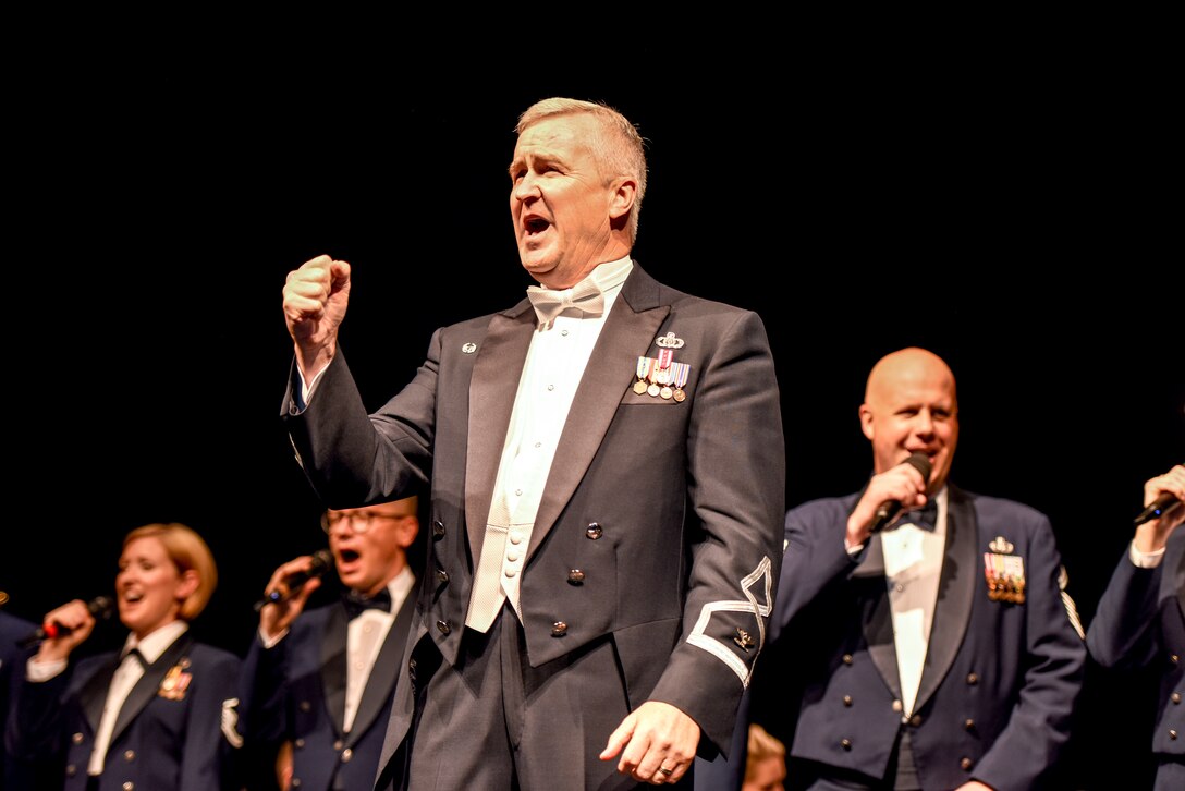 U.S. Air Force Col. Larry Lang, Air Force Band commander, sings, “America the Beautiful” with audience members, the U.S. Air Force Concert Band and Singing Sergeants during a concert  at the Murphey Performance Hall in San Angelo, Texas, Oct. 22, 2018. Lang has commanded the Air Force Band since 2012. (U.S. Air Force photo by Aryn Lockhart/Released)