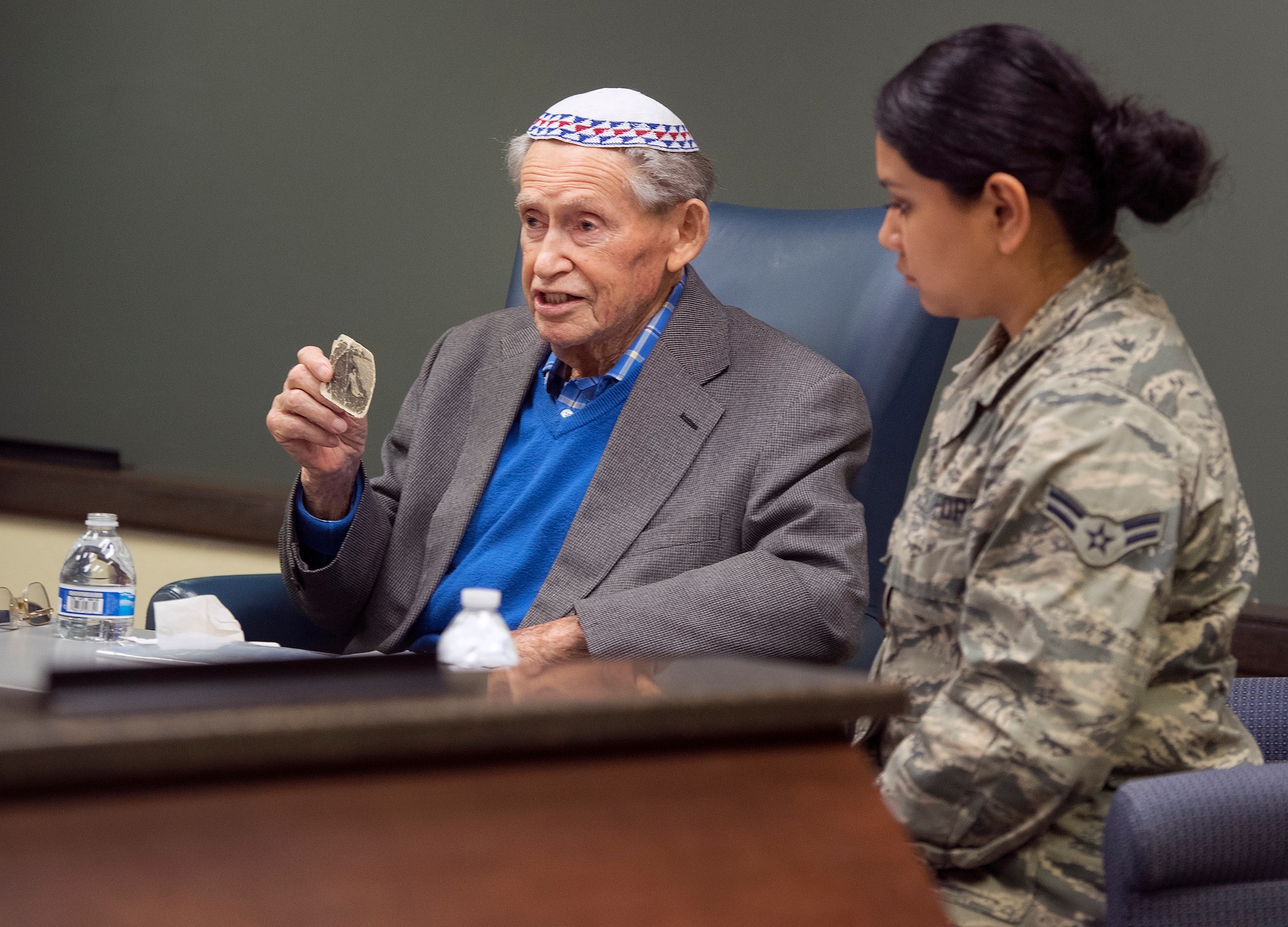 Sam Heider, a Holocaust survivor, holds up a picture of his sister, who was killed by the Nazis, as he talks about his experiences during World War II during a presentation Oct. 19, 2018, at the Air Force Life Cycle Management Center headquarters on Wright-Patterson Air Force Base, Ohio. Heider managed to keep the photo with him and hidden throughout his imprisonment in German concentration camps. It is the only photo he has of any of his family members who all died in the Holocaust. (U.S. Air Force photo by R.J. Oriez)