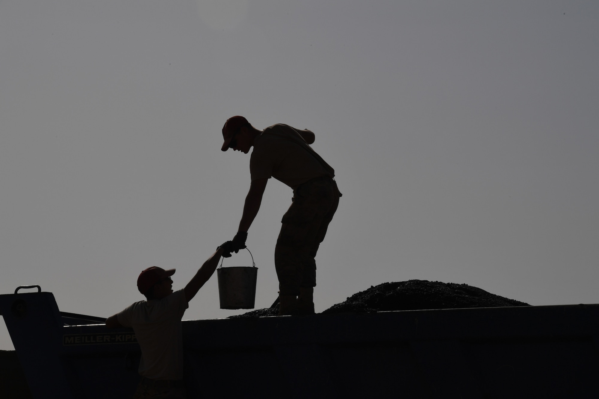 Airmen assigned to the 31st Expeditionary Rapid Engineer Deployable Heavy Operation Repair Squadron Engineer Squadron collect a sample of asphalt prior to paving a test road on Nigerien Air Base 201, Niger, Oct. 19, 2018. The test allows the engineers to determine the quality of the asphalt and test the equipment before laying the runway. (U.S. Air Force photo by Tech. Sgt. Rachelle Coleman)