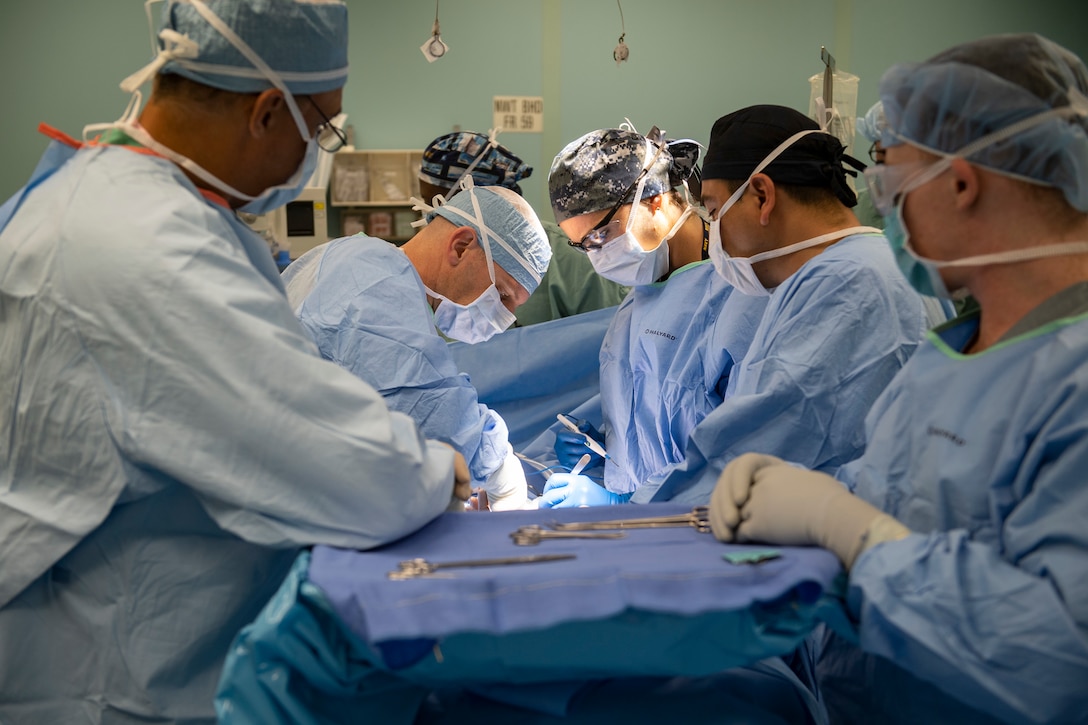 Doctors conduct an umbilical hernia surgery aboard the hospital ship USNS Comfort in Ecuador.