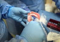A dental specialist smooths a dental mold during the surgical portion of the prosthodontics update course at Joint Base San Antonio-Lackland. The seven-day curriculum provides advanced hands-on and didactic training for dental specialists.