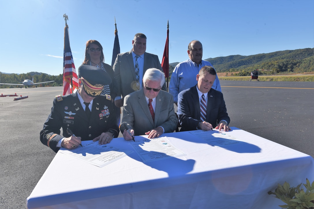 (Front Row, Left to Right) Lt. Col. Cullen Jones, Nashville District commander; U.S. Rep. Hal Rogers, representing Kentucky’s 5th Congressional District, and Dan Mosley, Harlan County Judge Executive, sign a partnership agreement at Tucker Guthrie Memorial Airport Oct. 18, 2018 to formally announce the extension of sewer services to 50 residences and 20 commercial structures along Airport Road. (USACE photo by Lee Roberts)