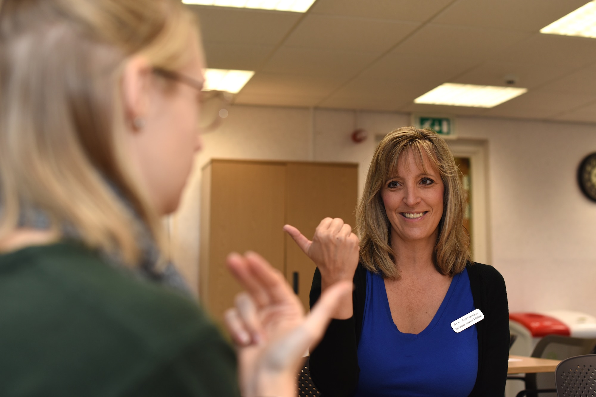 Ann Alexander, 100th Force Support Squadron sign language interpreter, helps Alicia Benoit with American Sign Language basics before an ASL workshop at RAF Mildenhall, England, Oct. 23, 2018. The Airman and Family Readiness Center provided Airmen and families with the workshop in honor of National Disability Employment Awareness Month. (U.S. Air Force photo by Airman 1st Class Brandon Esau)