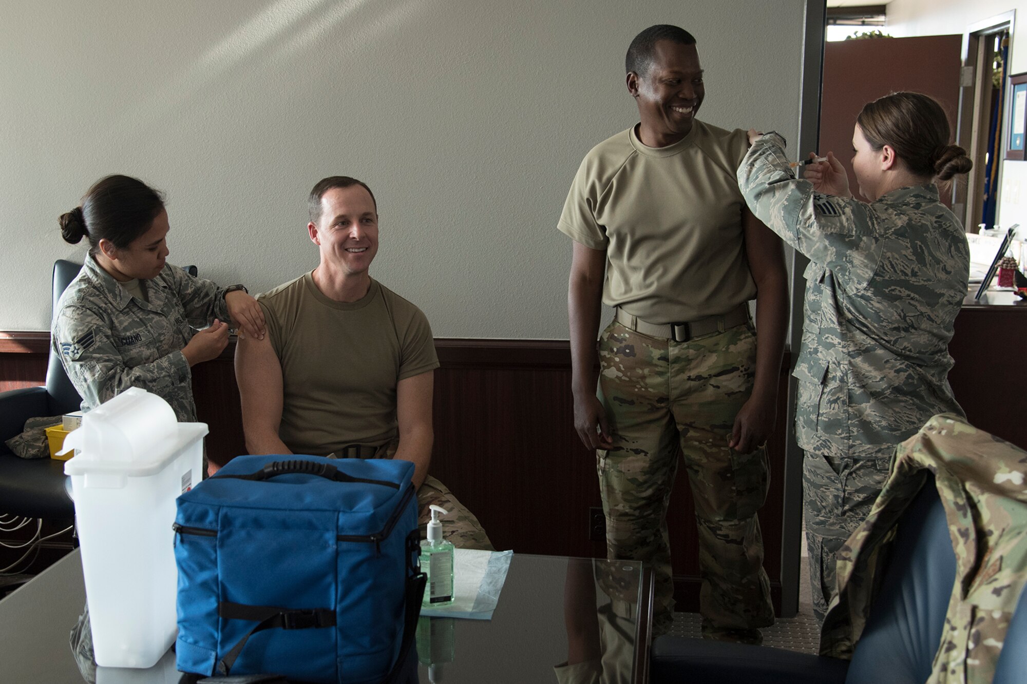 Col. Todd Moore (left), 21st Space Wing commander, and Chief Master Sgt. Jacob C. Simmons, 21st SW command chief, receive their flu shots at the 21st SW headquarters building on Peterson Air Force Base, Colo., Oct. 22, 2018.