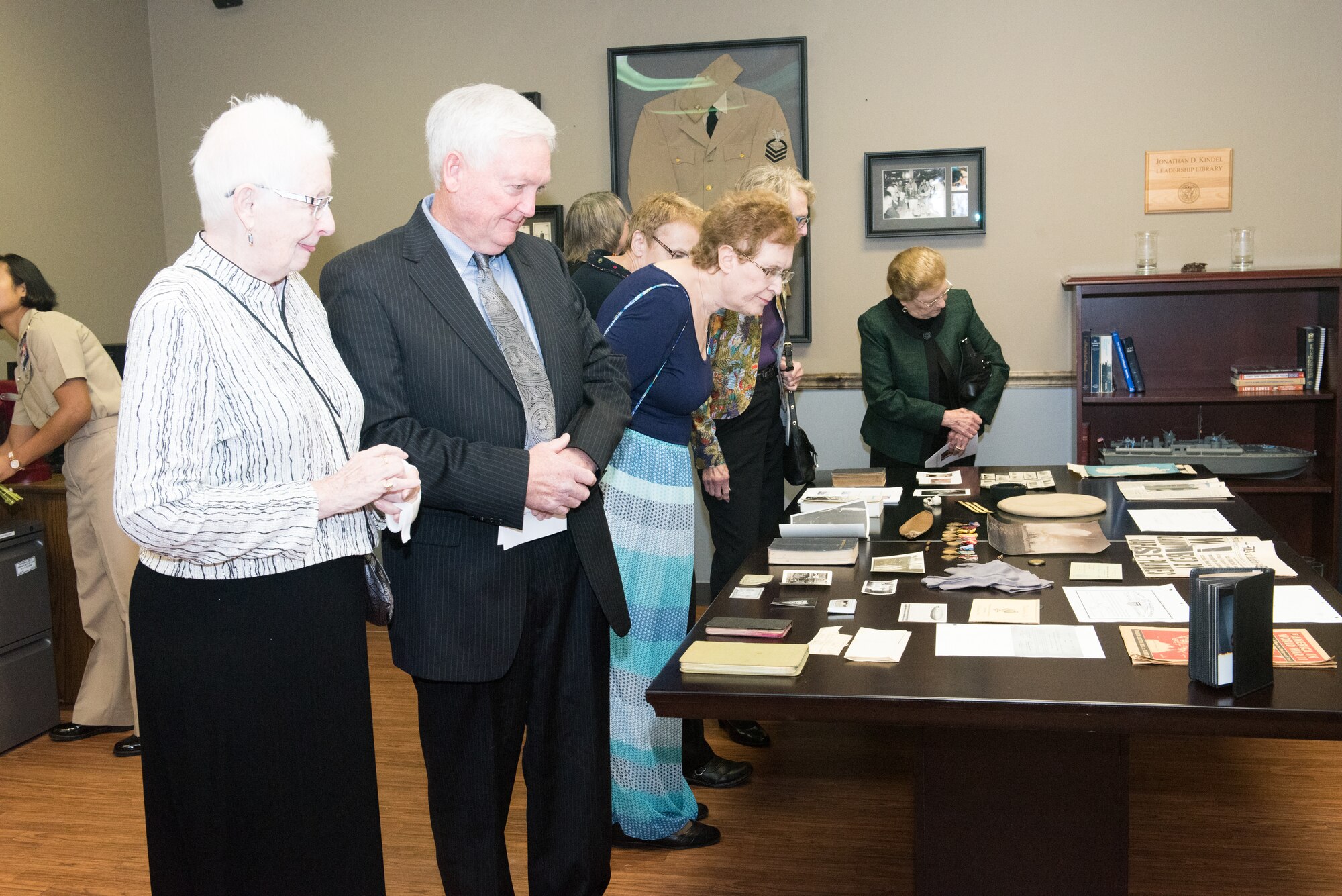 Linda Sheeran, wife of U.S. Navy veteran and retired Chief Petty Officer John Sheeran, and his son, John, look at mementos from John’s naval career during following the Great Plains Chief Petty Officer Association dedication ceremony of their Chief’s Mess at the 55th Operations Support Squadron Oct. 20, 2018.