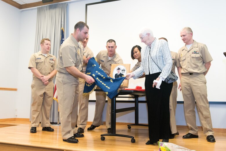 Linda Sheeran, wife of U.S. Navy veteran and retired Chief Petty Officer John Sheeran, officially unveils the plaque that rededicates the Great Plains Chief Petty Officer Association’s Chief’s Mess after her late husband during a ceremony at the 55th Operations Support Squadron Oct. 20, 2018.