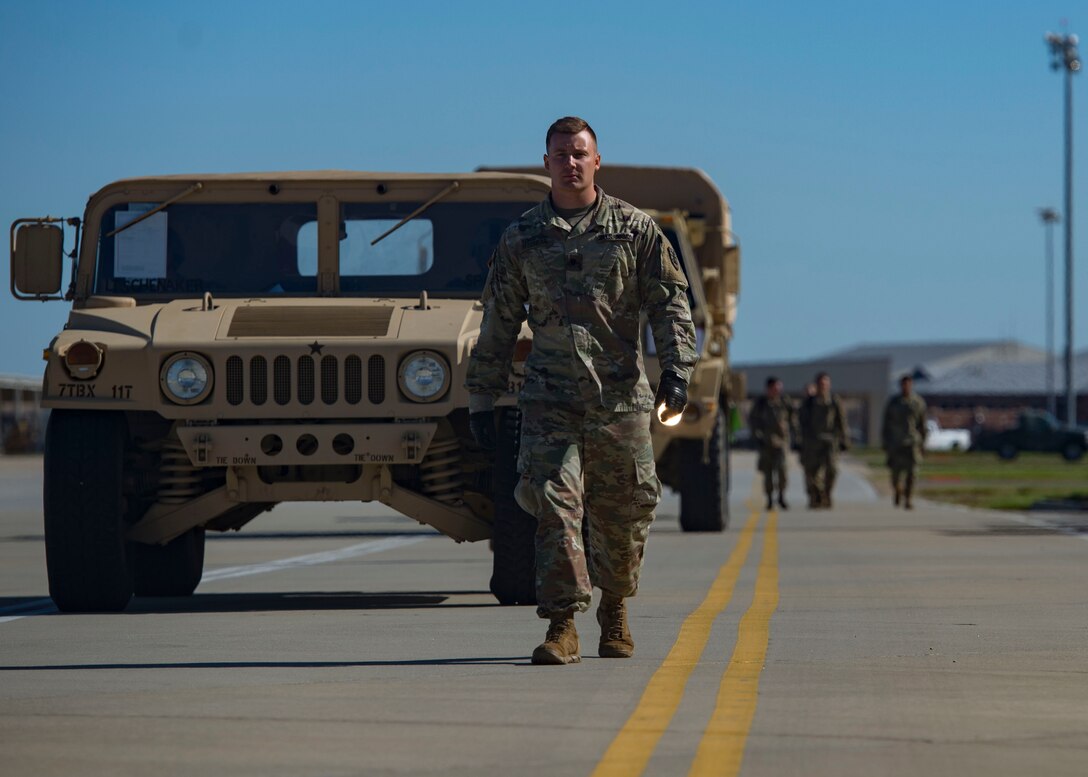 U.S. Army Spc. Brett Tessnear, 119th Inland Cargo Transfer Company, 11th Transportation Battalion, 7th Transportation Brigade (Expeditionary) motor transport operator, leads vehicles on the flight line during a training exercise at Joint Base Langley-Eustis, Virginia, Oct. 18, 2018.