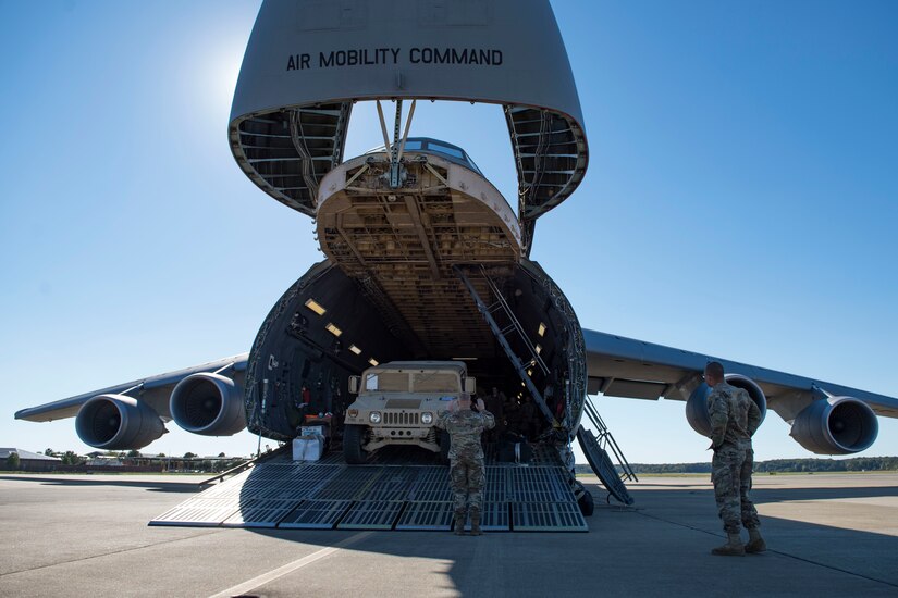 U.S. Army Soldiers assigned to the 119th Inland Cargo Transfer Company, 11th Transportation Battalion, 7th Transportation Brigade (Expeditionary) guide vehicles onto a U.S. Air Force C-5M Super Galaxy during a training exercise at Joint Base Langley-Eustis, Virginia, Oct. 18, 2018.