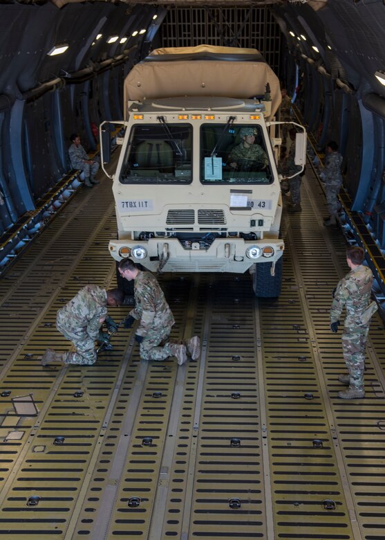 U.S. Army Soldiers assigned to the 11th Transportation Battalion, Headquarters and Headquarters Detachment, 7th Transportation Brigade (Expeditionary), secure a cargo truck aboard a U.S. Air Force C-5M Super Galaxy during a training exercise at Joint Base Langley-Eustis, Virginia, Oct. 19, 2018.