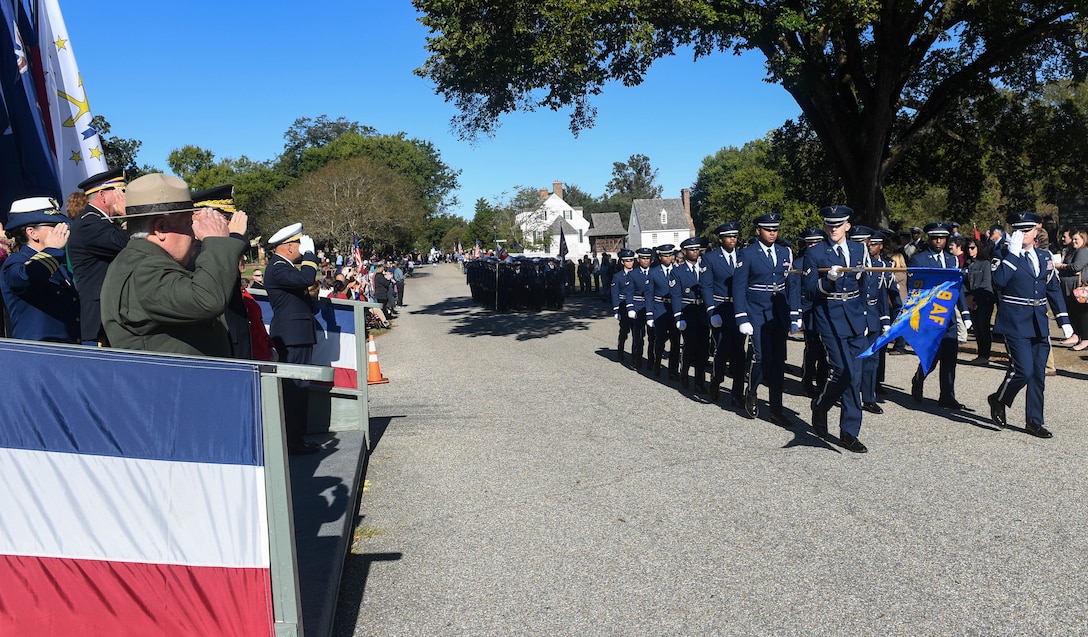 Senior leaders in the reviewing stand render a salute as the Langley Honor Guard marches past during the Yorktown Day parade at Colonial National Historic Park in Yorktown, Virginia, Oct. 19, 2018.