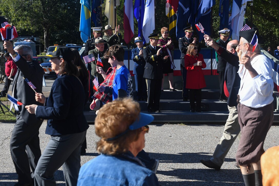 U.S. Army Col. Edward Vedder, 633rd Air Base Wing vice commander, cheers on marching participants during the Yorktown Day parade at Colonial National Historic Park, Virginia, Oct. 19, 2018.