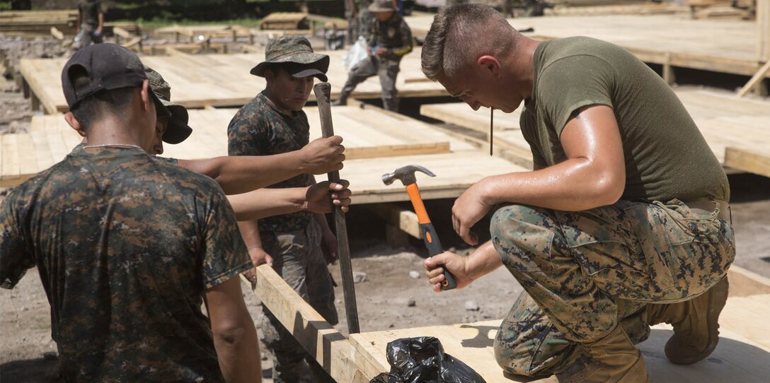 U.S. Marines and Guatemala military members work at a construction site.