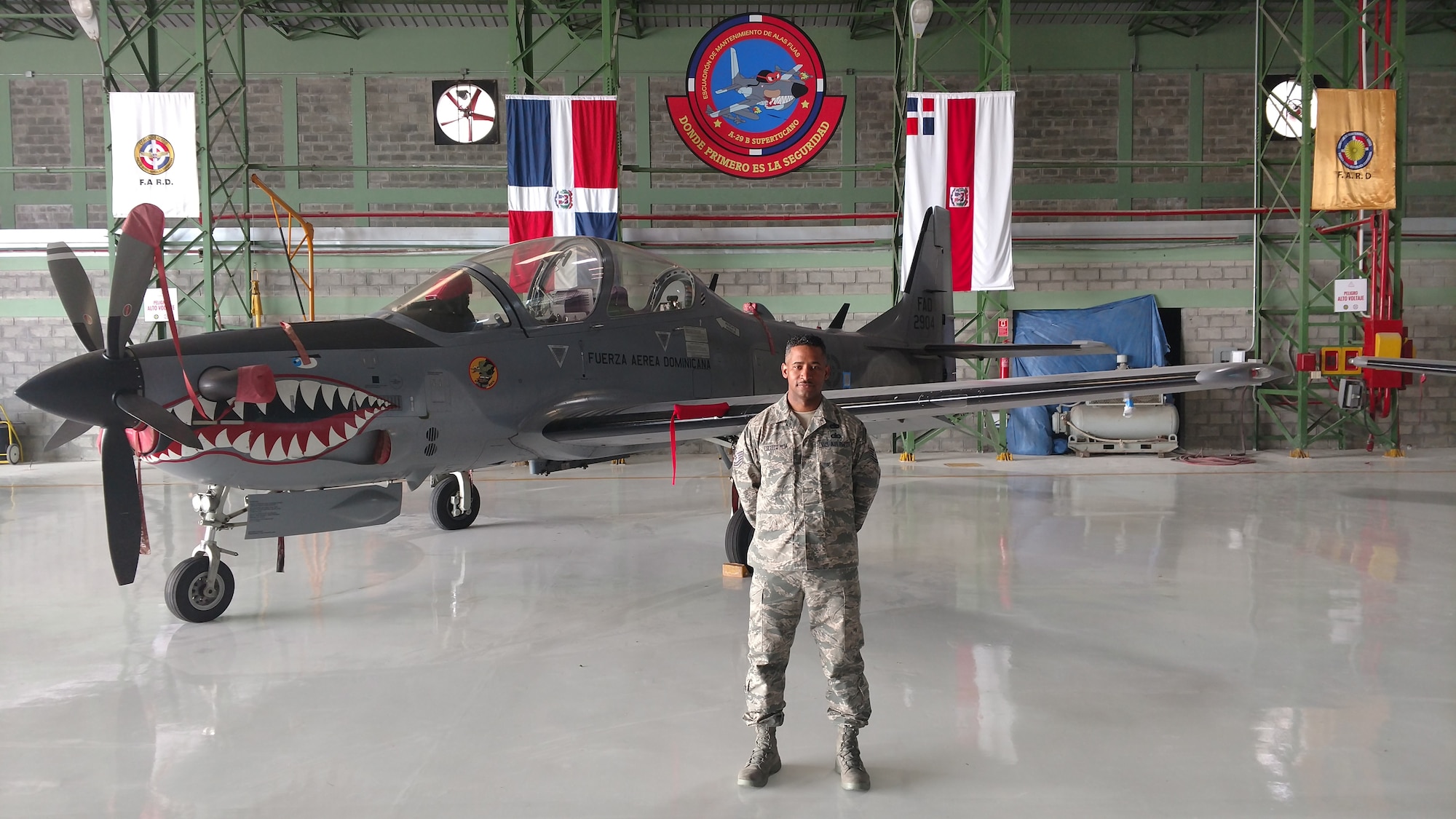 Tech. Sgt. Rafael Escoto Roa, 571st Mobility Support Advisory Squadron air transportation specialist air advisor, poses in-front of an A-29 Super Tucano aircraft, at the San Isidro Air Base in Santo Domingo, Dominican Republic. (Courtesy Photo)