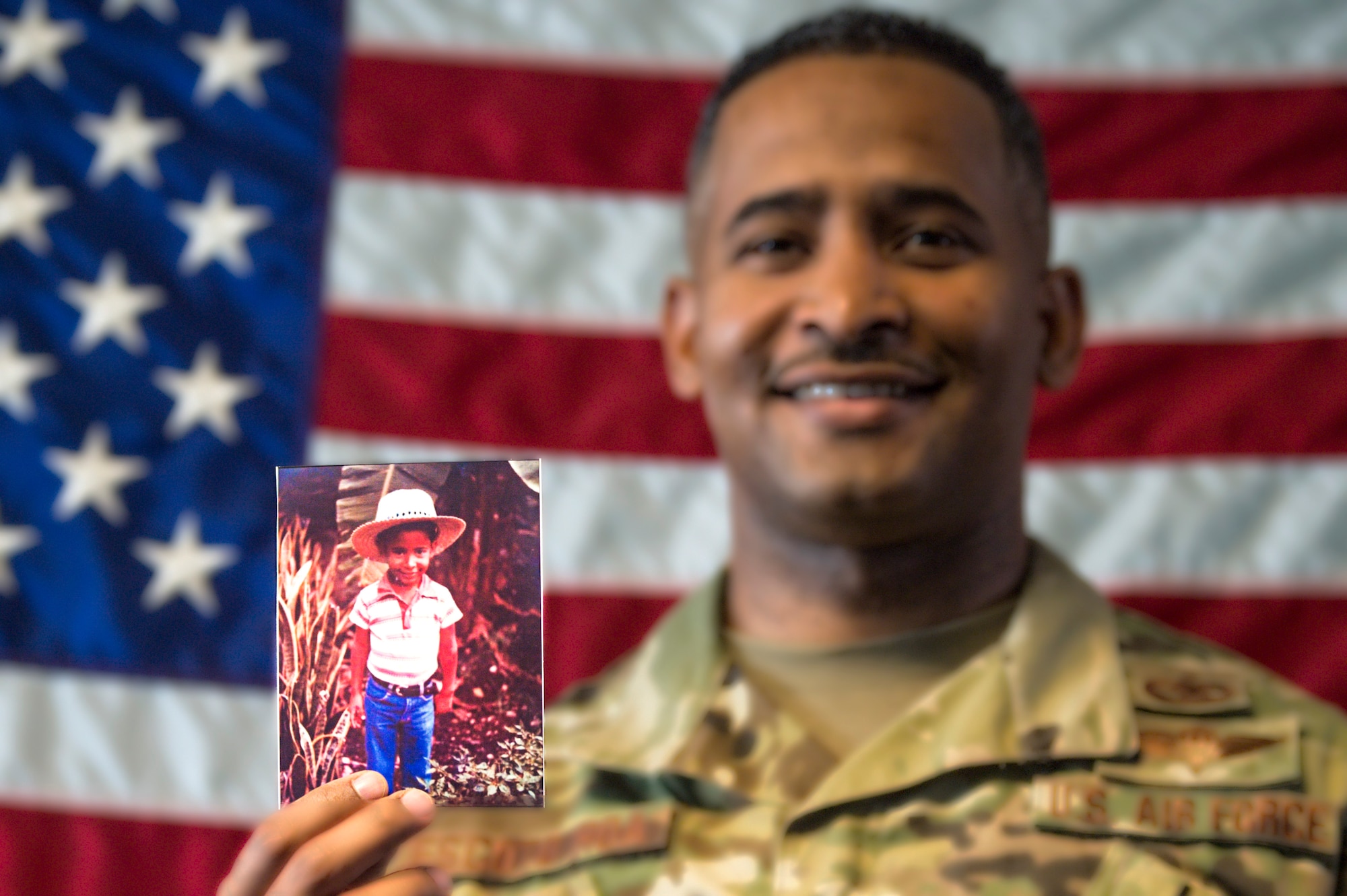 Tech. Sgt. Rafael Escoto Roa, 571st Mobility Support Advisory Squadron air transportation specialist air advisor, holds a picture of himself as a child, as he tells the story of his life in the Dominican Republic and how he moved to the United States in pursuit of the American dream. (U.S. Air Force photo by Tech. Sgt. Liliana Moreno)