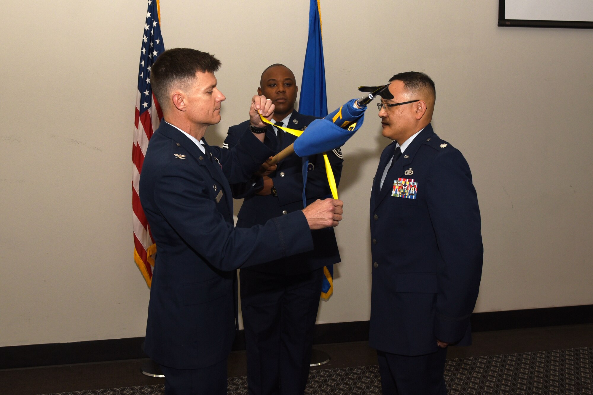 U.S. Air Force Col. Thomas Coakley, 17th Training Group commander, unfurls the 313th Training Squadron guideon during the 313th TRS Assumption of Command at the Event Center on Goodfellow Air Force Base, Texas, Oct. 24, 2018. The guideon was bound because the 313th TRS was inactive before the assumption of command ceremony. (U.S. Air Force photo by Staff Sgt. Joshua Edwards/Released)