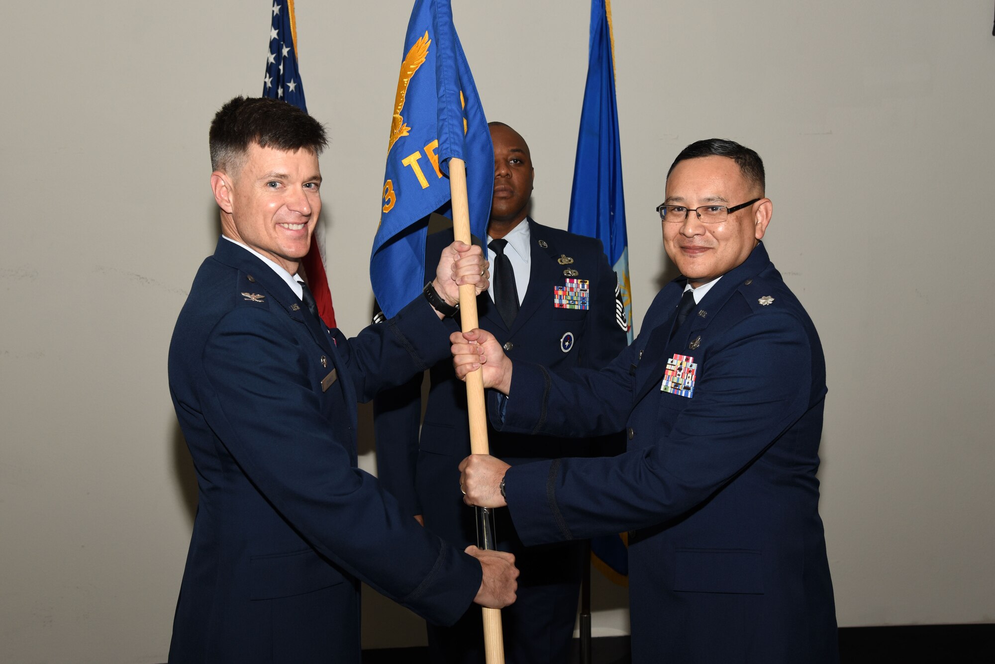 U.S. Air Force Col. Thomas Coakley, 17th Training Group commander, passes the 313th Training Squadron guideon to Lt. Col. David Sarabia, 313th TRS commander, during the 313th TRS Assumption of Command at the Event Center on Goodfellow Air Force Base, Texas, Oct. 24, 2018. As the 313th TRS commander, Sarabia is responsible for providing world-class international, mission-qualification, as well as intermediate and advanced intelligence, surveillance and reconnaissance training to develop and inspire professionals for the Department of Defense and our international partners. (U.S. Air Force photo by Staff Sgt. Joshua Edwards/Released)