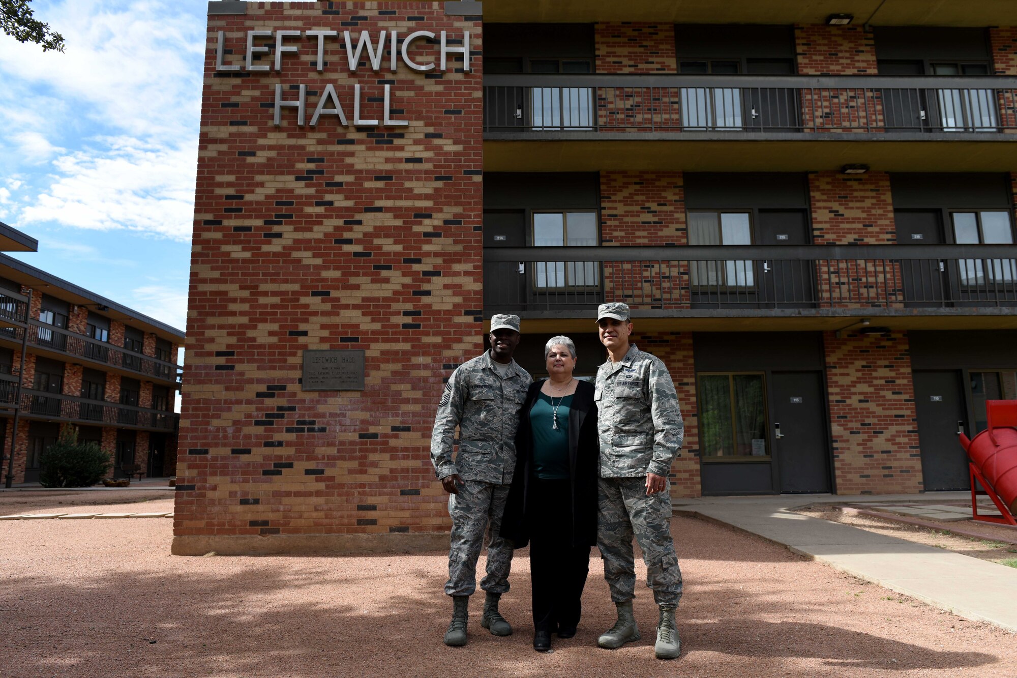 U.S. Air Force Chief Master Sgt. Lavor Kirkpatrick, 17th Training Wing command chief, 17th Medical Group Admin Support Rhonda Leftwich, and Col. Ricky Mills, 17th TRW commander, stand near Leftwich Hall on Goodfellow Air Force Base, Texas, Oct, 23, 2018. Goodfellow honored Tech. Sgt. Raymond Leftwich at the Taylor Chapel and outside the building that bears his name. (U.S. Air Force photo by Senior Airman Randall Moose/Released)