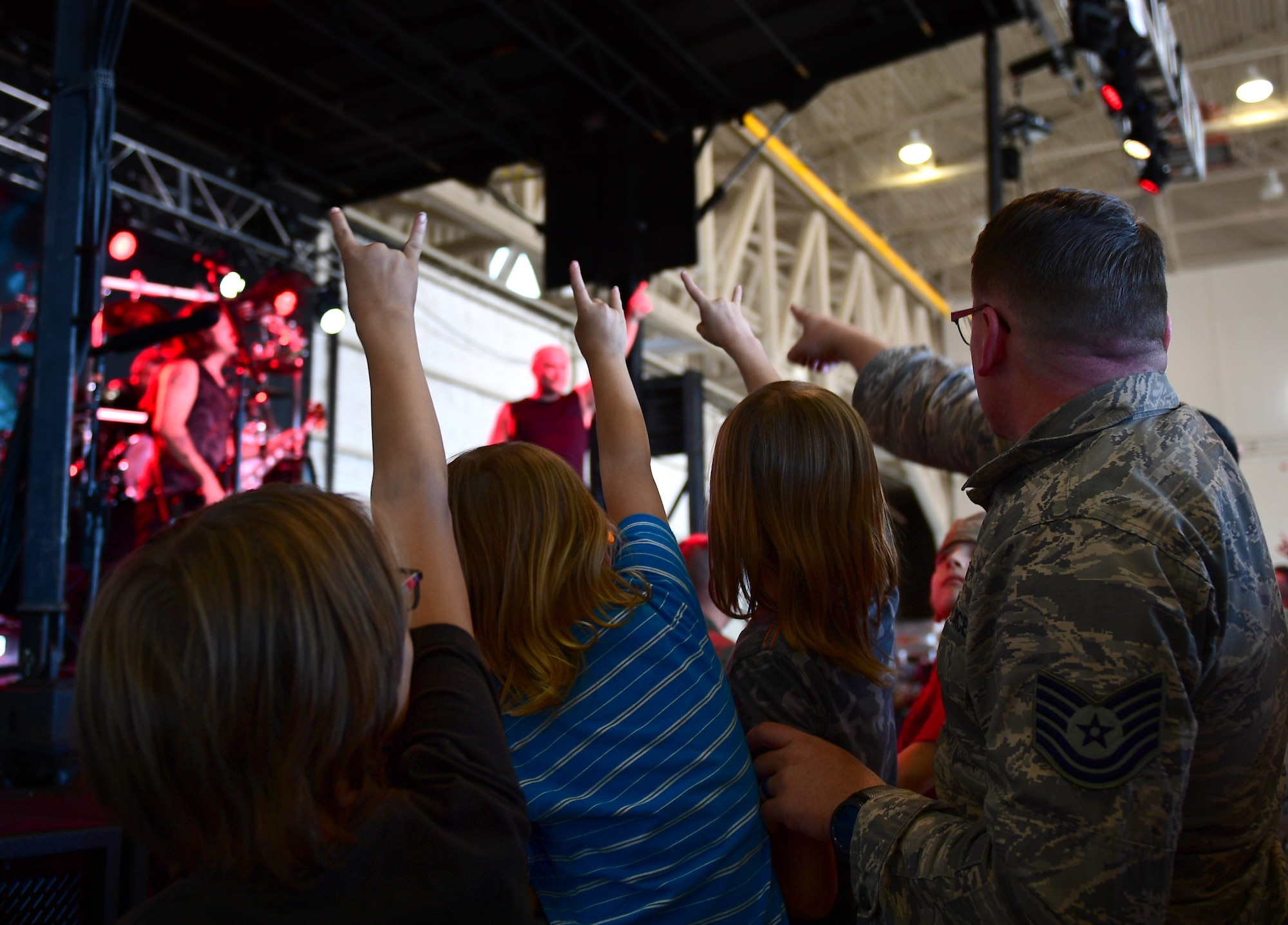 An Airman and his children enjoy the front row of a Disturbed concert at Creech Air Force Base, Nevada, Oct. 23, 2018. Disturbed partnered with the USO to perform a concert for Creech Airmen after learning about the wing mission. (U.S. Air Force photo by Senior Airman Christian Clausen)