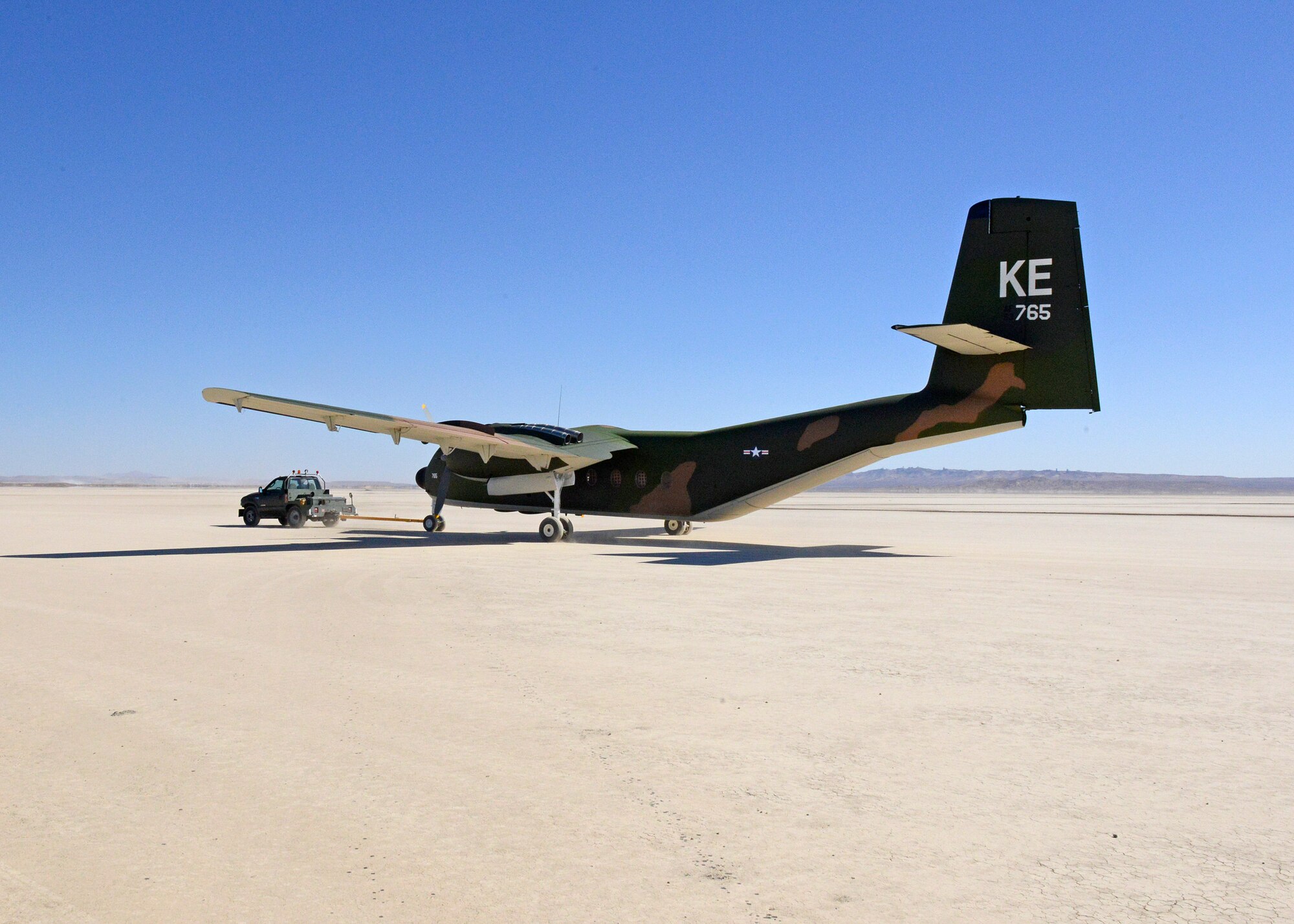 A C-7A Caribou is towed across Rogers Dry Lakebed from Edwards AFB's main base to the Air Force Flight Test Museum restoration hangar Oct. 15. (U.S. Air Force photo by Kenji Thuloweit)
