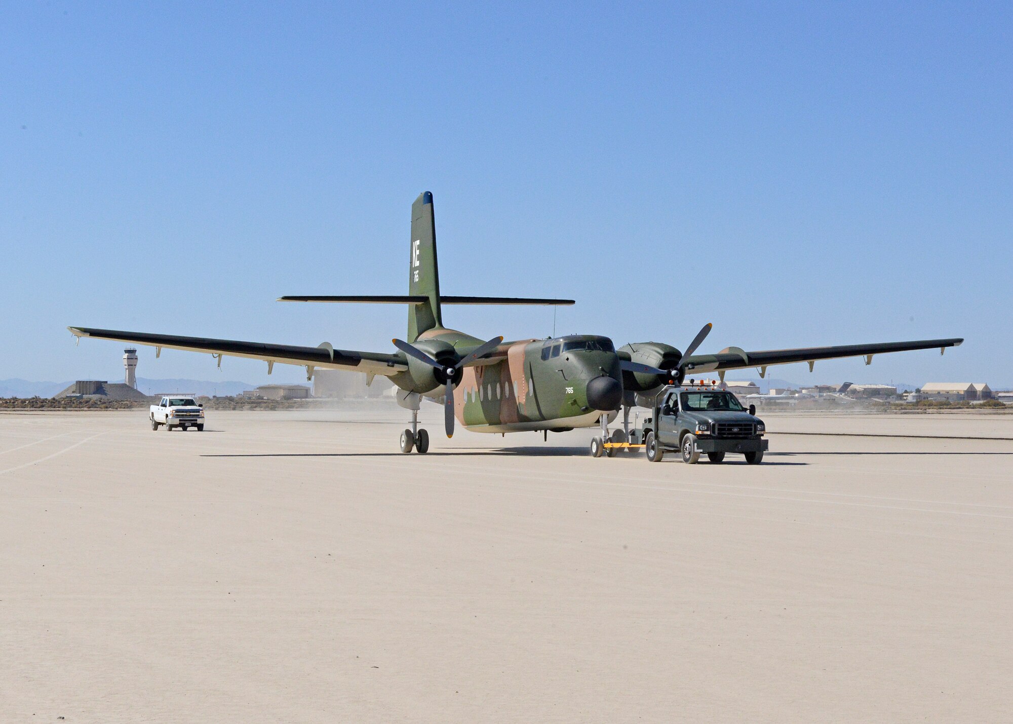A C-7A Caribou is towed across Rogers Dry Lakebed from Edwards AFB's main base to the Air Force Flight Test Museum restoration hangar Oct. 15. (U.S. Air Force photo by Kenji Thuloweit)