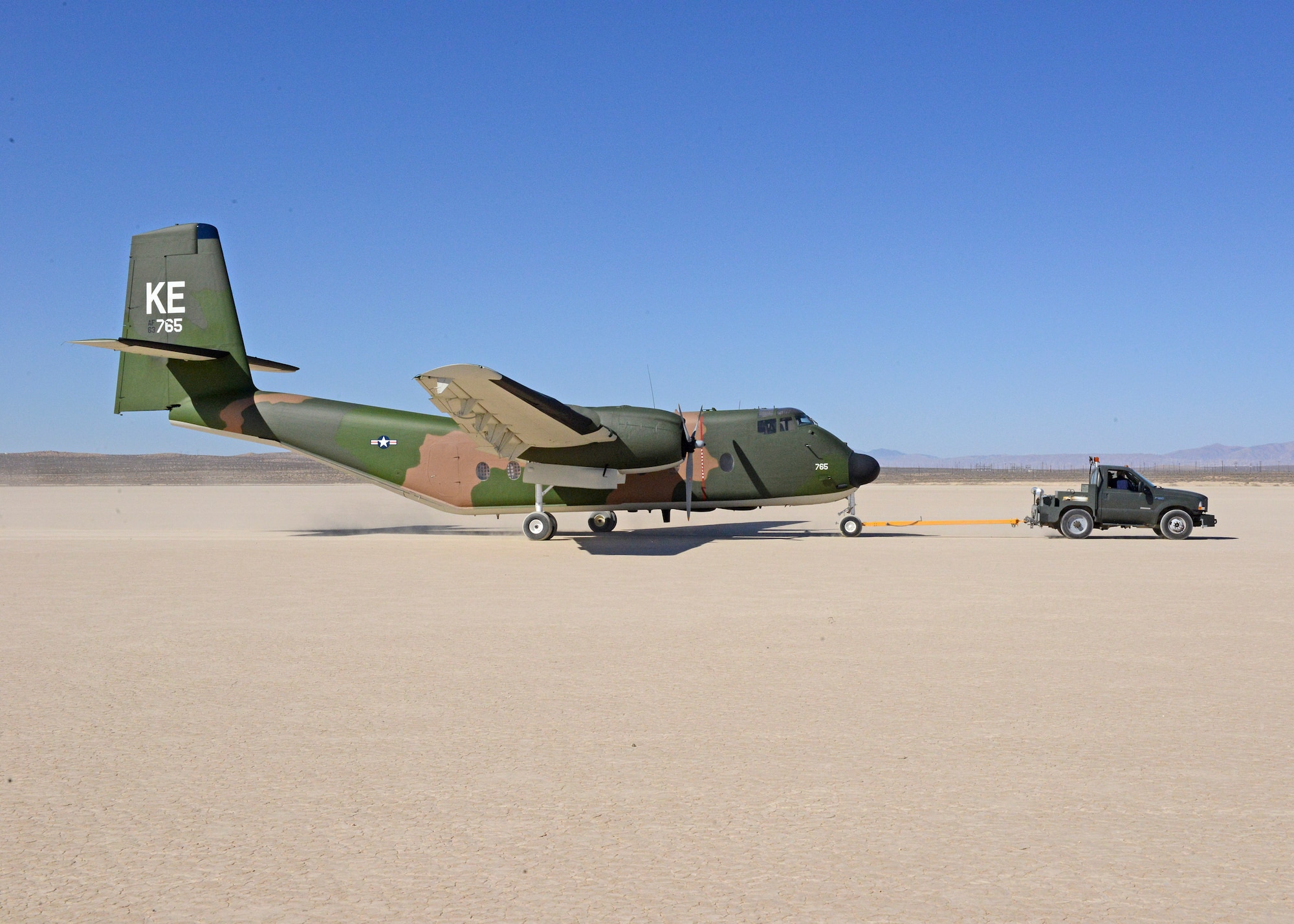 A C-7A Caribou is towed across Rogers Dry Lakebed from Edwards AFB's main base to the Air Force Flight Test Museum restoration hangar Oct. 15. (U.S. Air Force photo by Kenji Thuloweit)