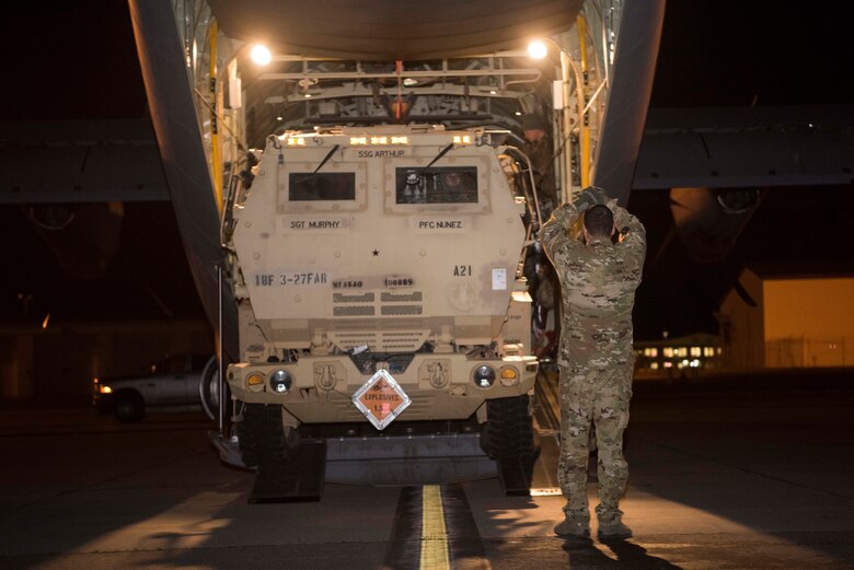 U.S. Air Force Senior Airman Armando McCarty, a 327th Airlift Squadron loadmaster assigned to Little Rock Air Force Base, Ark., instructs U.S. Army Pfc. Jacob Seaman, a High Mobility Artillery Rocket System (HIMARS) driver assigned to Alpha Battery, 3rd Battalion, 27th Field Artillery Regiment (HIMARS), 18th Field Artillery Brigade, Fort Bragg, N.C., as he drives a M142 HIMARS into a U.S. Air Force C-130J Super Hercules during Red Flag-Alaska 19-1 at Joint Base Elmendorf-Richardson, Alaska, Oct. 19, 2018. The battery was tasked to provide long-range artillery support during RF-A, allowing the unit to showcase its capabilities and develop relationships with other services.