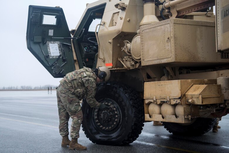 U.S. Army Pfc. Mary Slatten, a High Mobility Artillery Rocket System (HIMARS) driver, assigned to Alpha Battery, 3rd Battalion, 27th Field Artillery Regiment (HIMARS), 18th Field Artillery Brigade, Fort Bragg, N.C., deflates the tires of a M142 HIMARS at Fort Greely, Alaska, Oct. 19, 2018, during Red Flag-Alaska 19-1. Slatten’s unit was tasked to provide long-range artillery support during RF-A, allowing the unit to showcase its capabilities and develop relationships with other services. Transporting the M142 HIMARS in a U.S. Air Force C-130J Super Hercules requires deflating the tires and lowering the suspension.