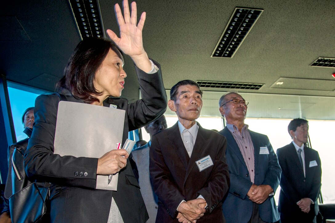 岩国基地で10月18日に実施された「サウンド・オブ・フリーダム（自由の音）」活動で、岩国市自治会連合会の方々を案内する妹尾陽子さん。岩国基地司令補佐官の妹尾さんは、「このような活動は非常に重要です。それは岩国基地が毎日、日米同盟関係の支援や日米両国の防衛、日米の一般市民の生活を守っていることを地域住民や自治体関係者、議員の方々に理解してもらう機会だからです。」と話す。妹尾さんはまた、この活動の目標について「基地の任務の中には日本の国防を間接的に支援しているものもあり、そのようなことについて、参加者の皆さんに理解を深めてもらうこと」だと付け加えた。妹尾さんの仕事は来訪者が基地の任務を理解し、なぜ海兵隊が日本に駐留しているのかを正しく理解してもらうこと。「サウンド・オブ・フリーダム（自由の音）」活動は、地元の指導者が基地の運用や第12海兵飛行大隊（MAG-12）の即応性維持の重要性を理解することに役立っている。
写真：リチャード・レモーン兵長