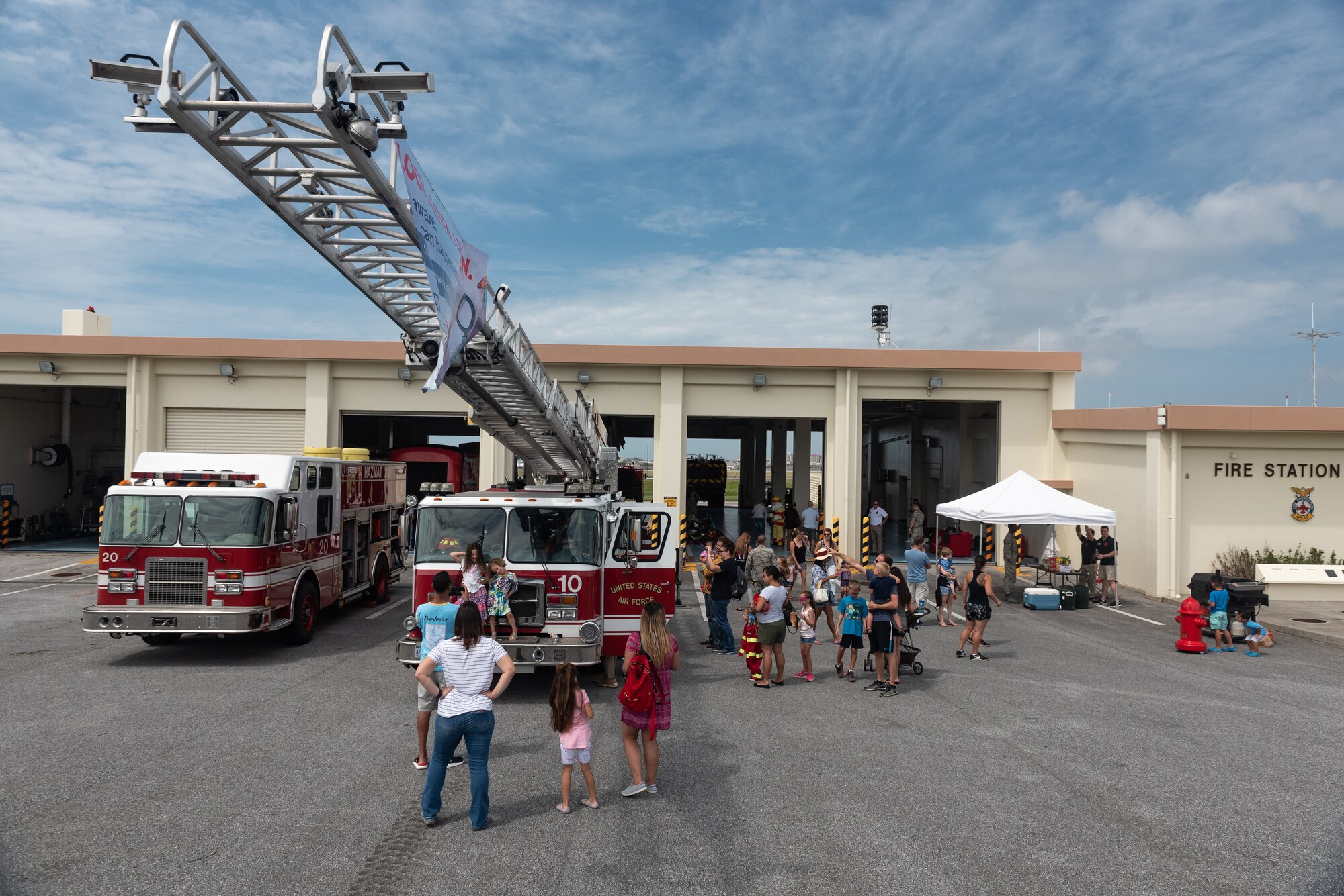 Participants of the Fire Station 1 Open House interact with firefighters and the equipment they use Oct. 6, 2018, on Kadena Air Base, Japan. The open house was hosted by the 18th Civil Engineer Squadron to raise awareness about fire safety during Fire Prevention Week. (U.S. Air Force photo by Staff Sgt. Micaiah Anthony)