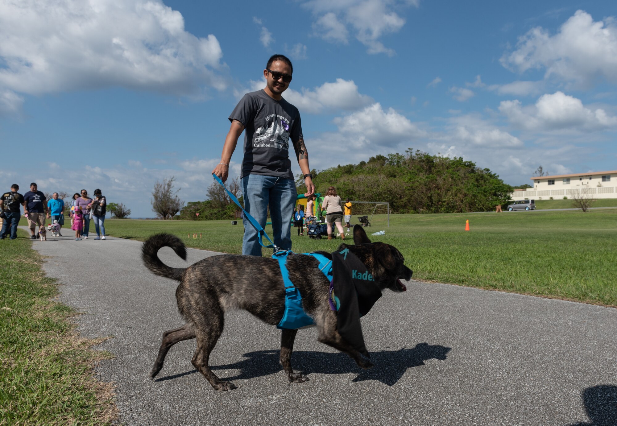 Calvin Collosi, 18th Comptroller Squadron unit deployment and training manager, walks his dog during the Paws Against Domestic Violence  event Oct. 20, 2018, at Kadena Air Base, Japan. U.S. Army, Air Force and Marine Corps family advocacy agencies came together to host the event to raise awareness for domestic violence for the Okinawa military community. (U.S. Air Force photo by Staff Sgt. Micaiah Anthony)