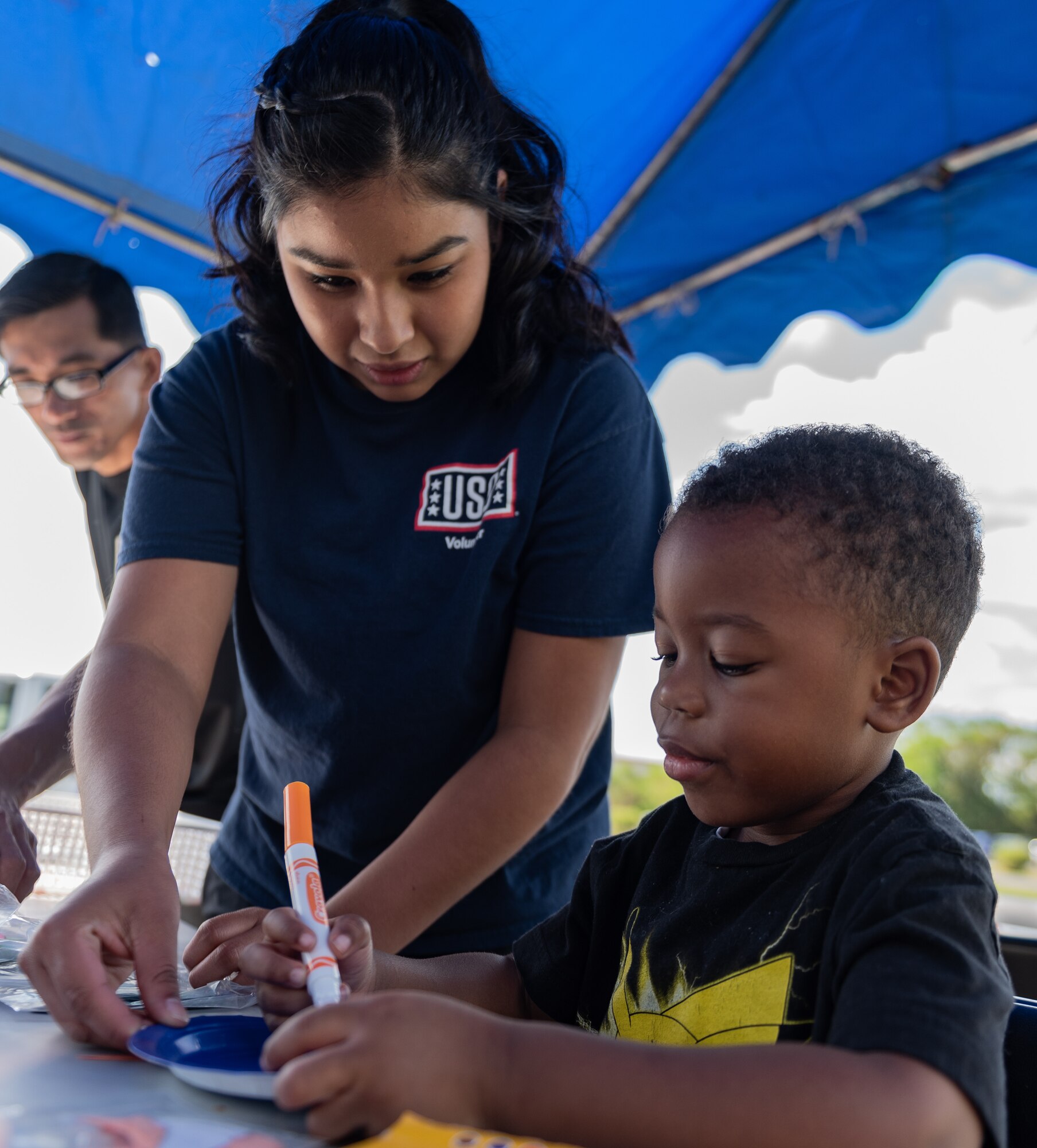 Berenise Tarin-Ruelas, Kadena United Service Organization volunteer, helps a child make crafts during the Paws Against Domestic Violence event Oct. 20, 2018, at Kadena Air Base, Japan. The event was hosted by U.S. Army, Air Force and Marine Corps family advocacy agencies stationed on Okinawa. Military family advocacy programs work to prevent domestic abuse, child abuse and child neglect by providing education and awareness programs for the military community. (U.S. Air Force photo by Staff Sgt. Micaiah Anthony)