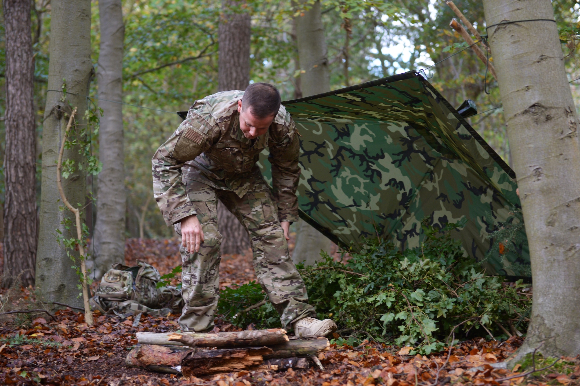 Tech. Sgt. Dereck Day, a 48th Operations Support Squadron Survival, Evasion, Resistance and Escape specialist, demonstrates how to build a reliable shelter at Royal Air Force Lakenheath, England, Oct. 18, 2018. Participants of the one-day SERE training were asked to build shelters from both natural and man-made resources to test their survival skills. (U.S. Air Force photo by Airman 1st Class Shanice Williams-Jones)