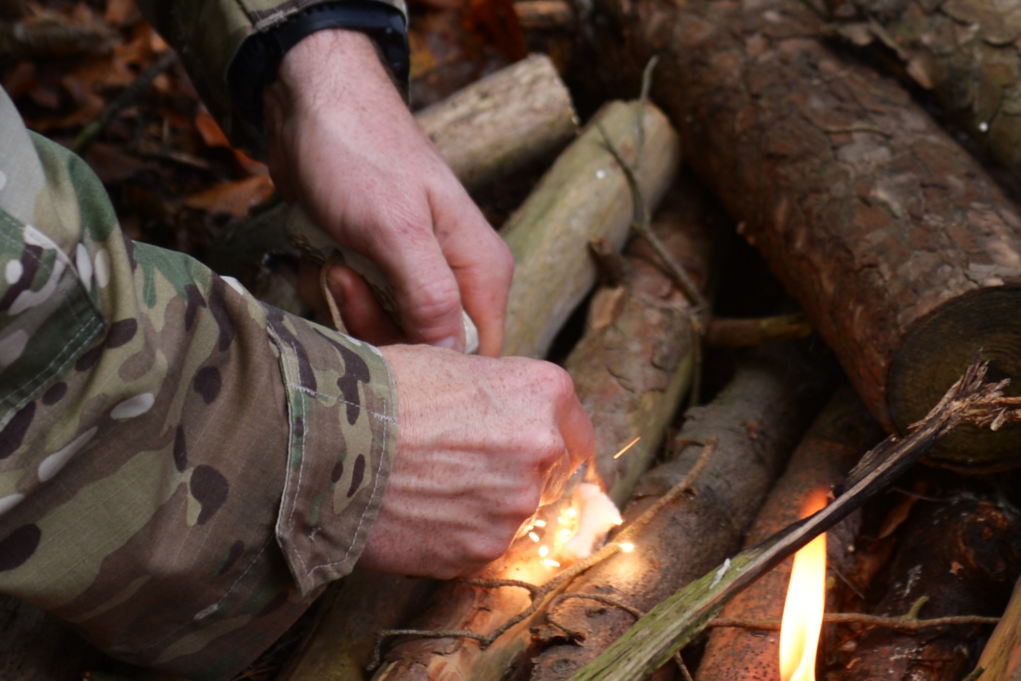Tech. Sgt. Dereck Day, a 48th Operations Support Squadron Survival, Evasion, Resistance and Escape specialist, demonstrates how to start a fire during SERE training at Royal Air Force Lakenheath, England, Oct. 18, 2018. SERE training participants learned how to build and use both warmth and signal fires. (U.S. Air Force photo by Airman 1st Class Shanice Williams-Jones)