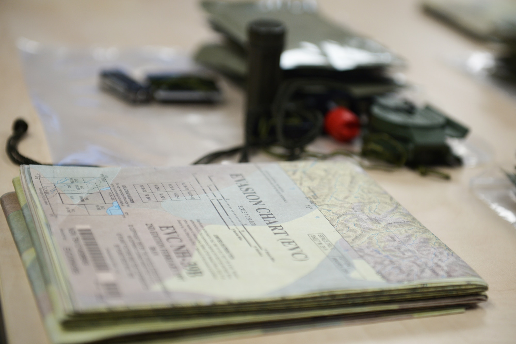 An Evasion Chart is added to survival kits at a Survival, Evasion, Resistance and Escape training program at Royal Air Force Lakenheath, England, Oct. 18, 2018. The EVC is a multi-use tool developed during World War II to help service members evade capture and navigate behind enemy lines. (U.S. Air Force photo by Airman 1st Class Shanice Williams-Jones)