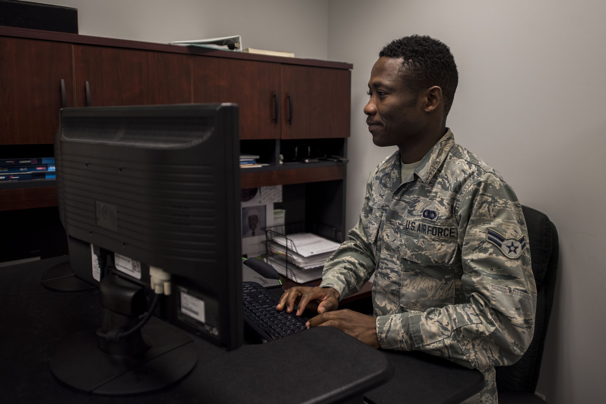 Airman 1st Class Sewa Gunn, 375th Operations Support Squadron commander support staff, tracks individual squadron member's records at Scott Air Force Base, Illinois on October 16, 2018. Gunn joined the Air Force one year after leaving his home country of Togo, Africa. Gunn recieved a visa through the Diversity Immigrant Visa program, which gives out 50,000 immigrant visas anually.(U.S. Air Force photo by Senior Airman Daniel Garcia)