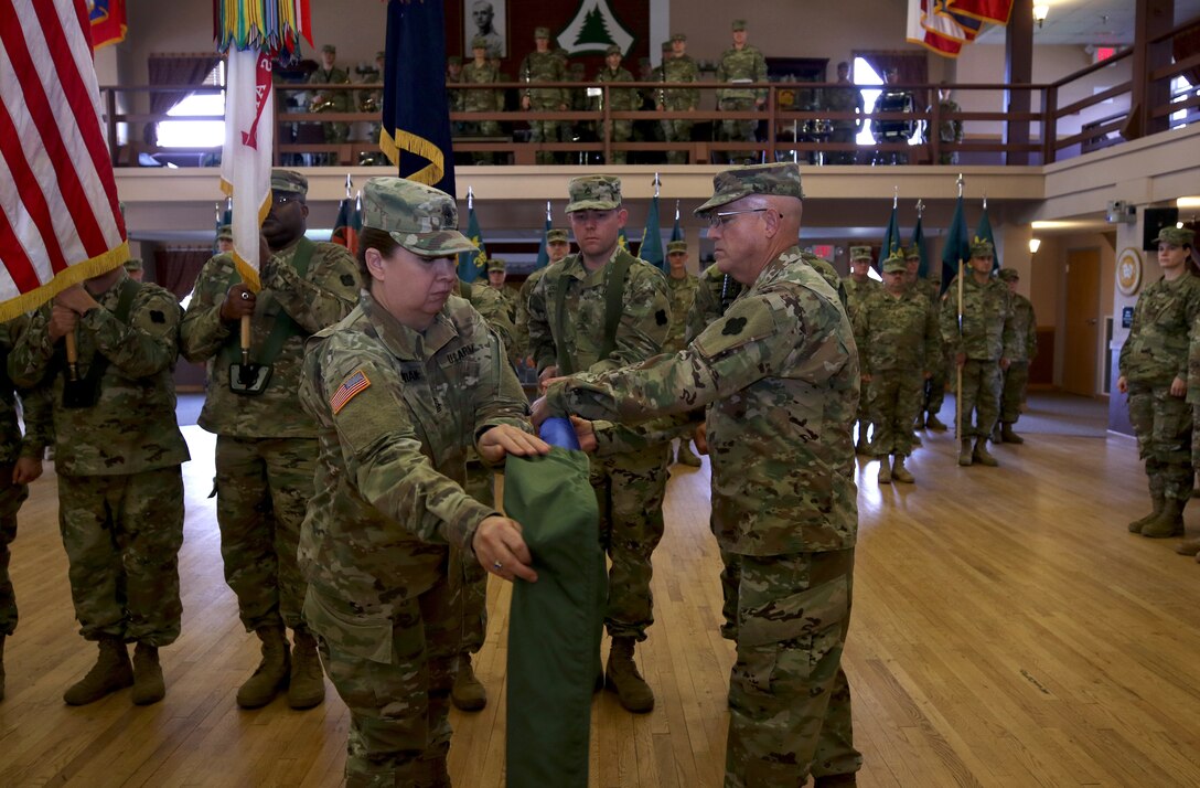 Command Sgt. Maj. Sara E. Noskowiak, Mission Command Support Group senior noncommissioned officer, uncases the colors during an unit activation and assumption of command ceremony at Fort McCoy, Wisconsin, Oct. 20, 2018. The MSCG will oversee the readiness and training of 20 small specialty units, so the units are able to stay mission focused.