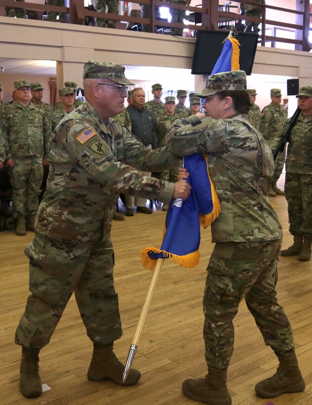 Col. Jeffrey D. Pugh, commander of the Mission Command Support Group, 88th Readiness Division passes the unit's new uncased colors to Command Sgt. Maj. Sara E. Noskowiak, MSCG senior noncommissioned officer, during a unit activation and assumption of command ceremony at Fort McCoy, Wisconsin, Oct. 20, 2018. The new brigade element will support specialty units, ensuring their readiness needs are met.