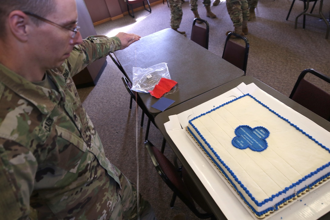 Staff Sgt. Robert D. Clark, Headquarters and Headquarters Company, 88th Readiness Division, religious affairs noncommissioned officer, cuts a red, white, and blue cake with dental floss after an assumption of command ceremony for the Mission Command Support Group, 88th Readiness Division, at Fort McCoy, Wisconsin, Oct. 20, 2018. He cleans the floss between every cut, keeping the cake looking pristine.