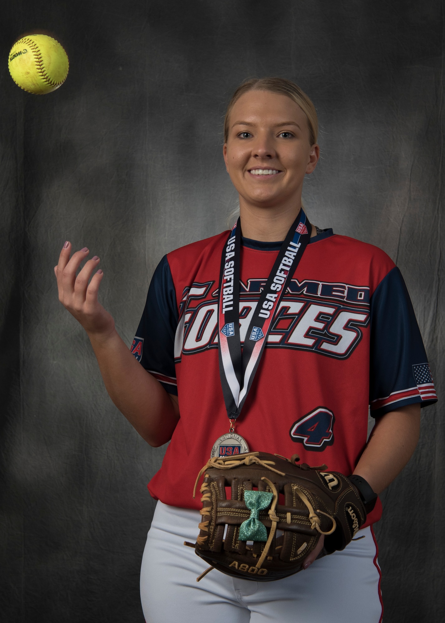 Senior Airman Tori Tilley poses for a personality portrait Oct. 4, in the Public Affairs Studio on Holloman Air Force Base, N.M. Tilley is in her U.S. Armed Forces Softball uniform with the silver Armed Forces medal she received competing this year. (U.S. Air Force photo by Airman Autumn Vogt)