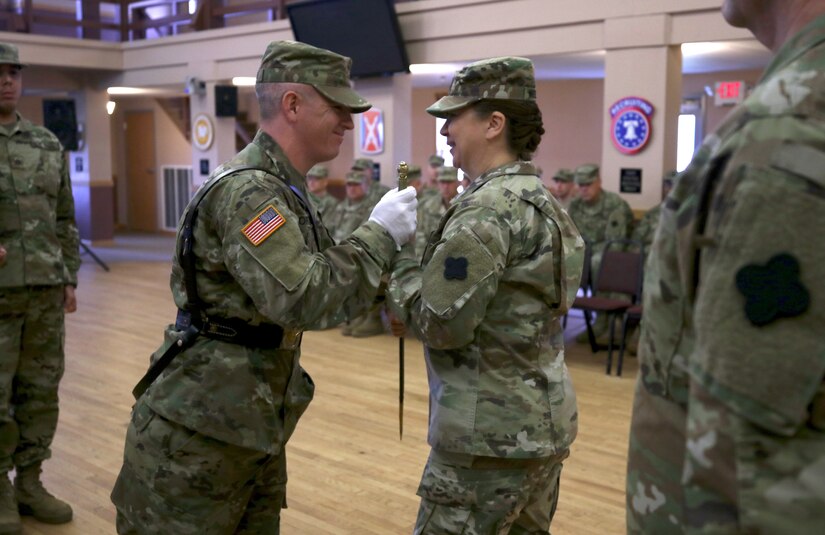 Sgt. Benjamin Moran, 338th Army Band, 88th Readiness Division, passes an 1840 U.S. noncommissioned officers sword to Command Sgt. Maj. Sara E. Noskowiak during a change of responsibility ceremony at Fort McCoy, Wisconsin, Oct. 20, 2018.