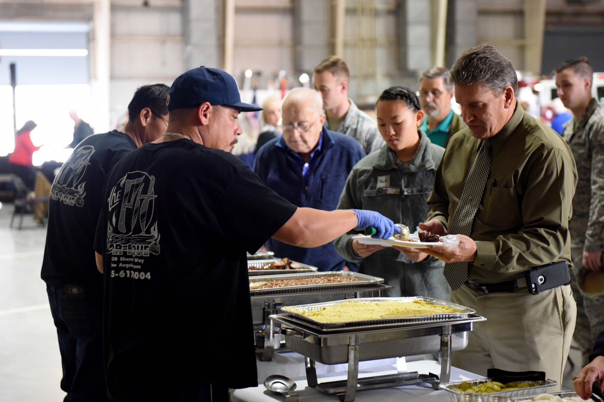 Participants grab food during Retiree Appreciation Day at the Louis F. Garland Department of Defense Fire Academy on Goodfellow Air Force Base, Texas, Oct. 25, 2018. Goodfellow provided free food, refreshments, music and a regulation drill display to the participants. (U.S. Air Force photo by Senior Airman Randall Moose/Released)