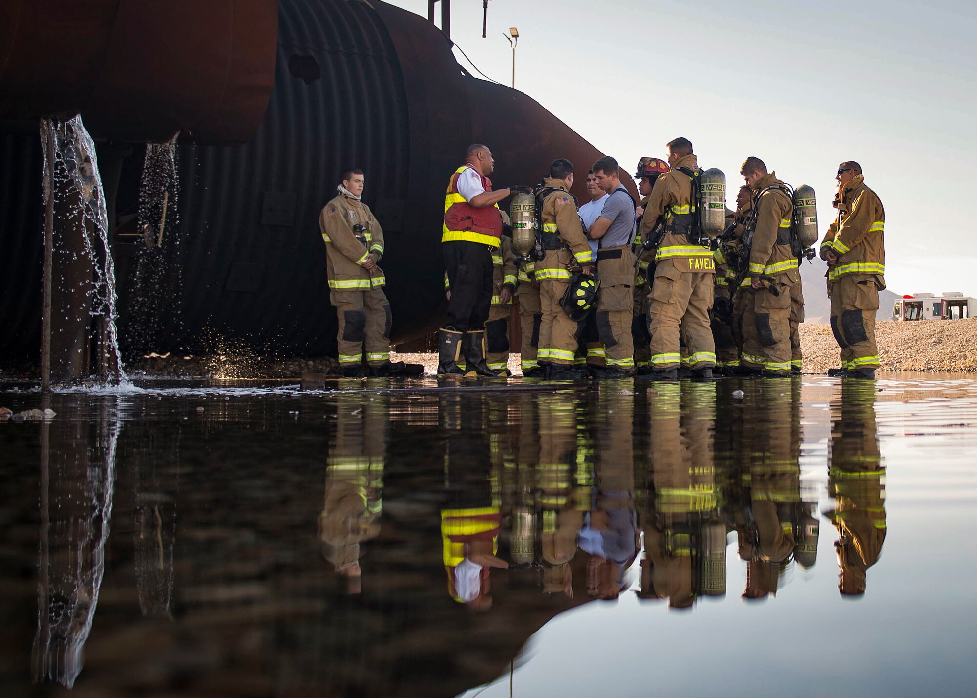 Firefighters assigned to the 99th Civil Engineer Squadron go over safety precautions before an exterior frontal training exercise at the fire department training area on Nellis Air Force Base, Nev., Oct 24, 2018. The purpose of the training is to ensure that personnel are trained in case of a fire emergency or aircraft crash in a multitude of different situations. (U.S. Air Force photo by Airman 1st Class Bryan T. Guthrie)