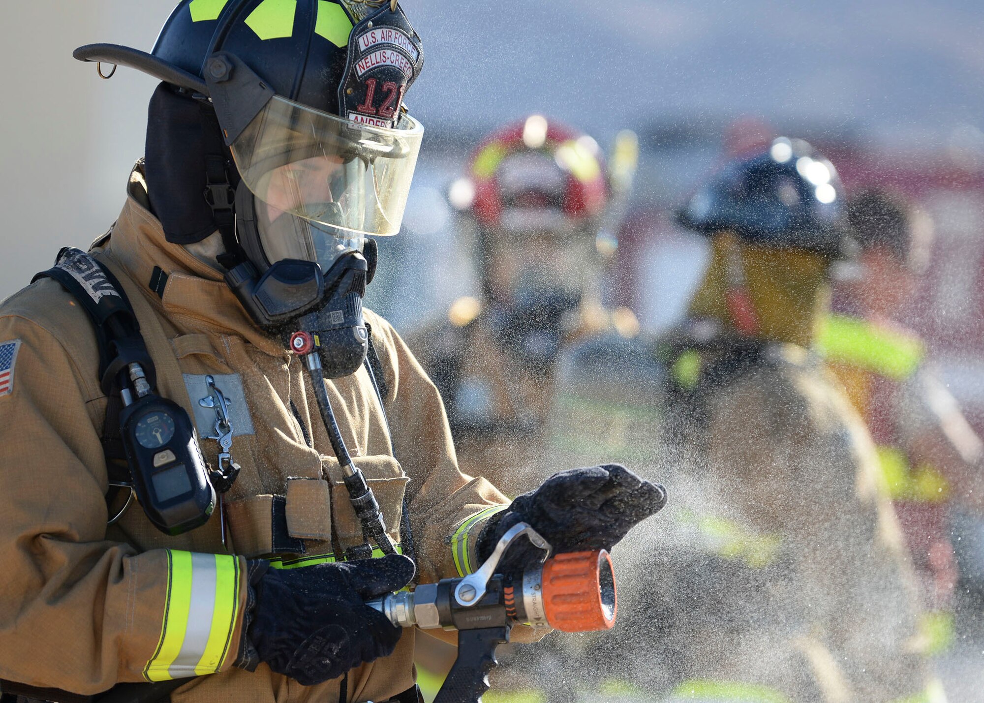 Lt. Andrew Anderson, 99th Civil Engineer firefighter, tests his fire hose during an exterior rear aircraft training at the fire department training area on Nellis Air Force Base, Nev. Oct 22, 2018. Airport and rescue fire fighting vehicles are designed to disperse around 2,000 gallons per minute. (U.S. Air Force photo by Airman 1st Class Bryan T. Guthrie)