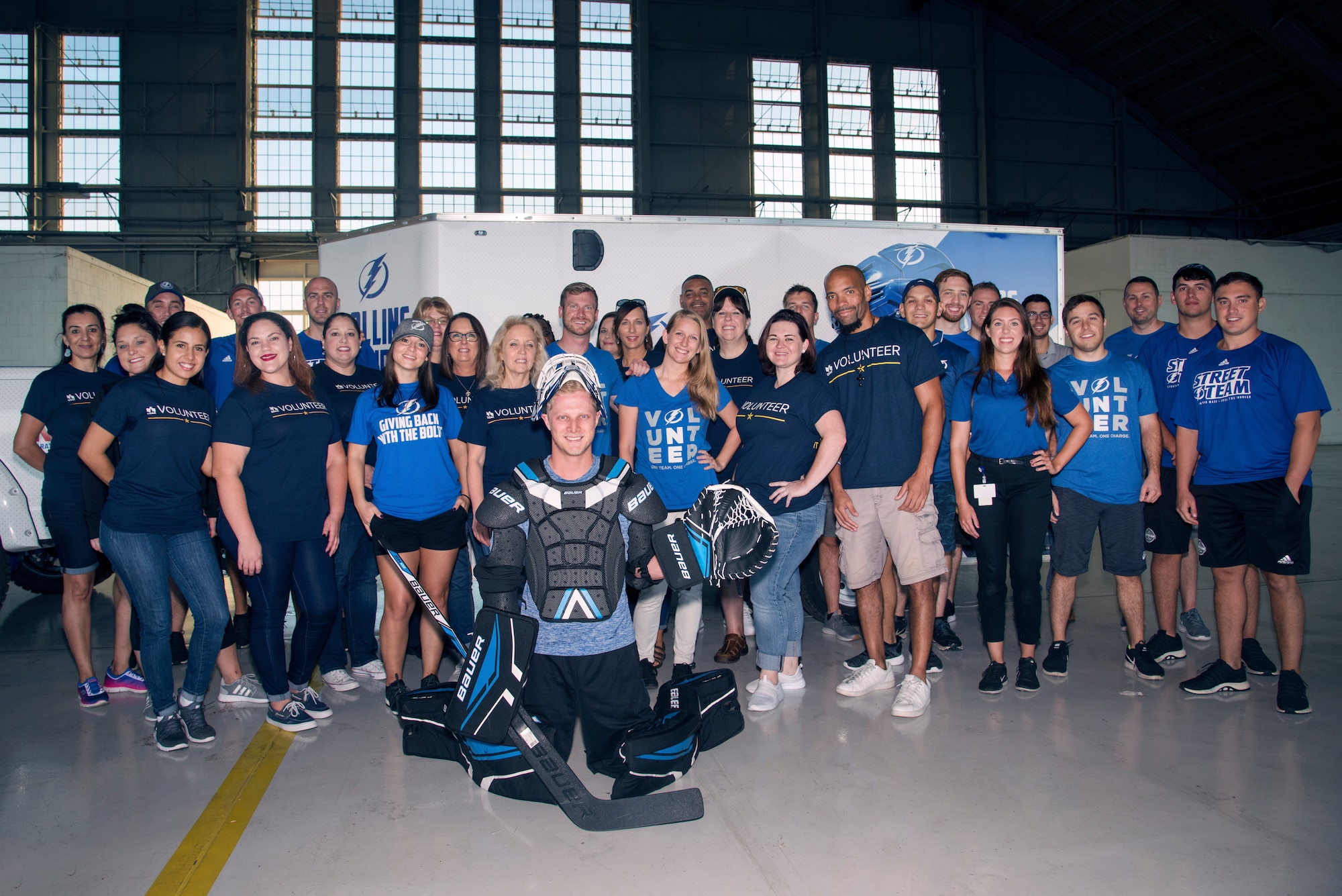 Tampa Bay Lightning’s Street Team and USAA volunteers pose for a photo at Hangar 4 on MacDill Air Force Base, Florida, Oct. 25, 2018.