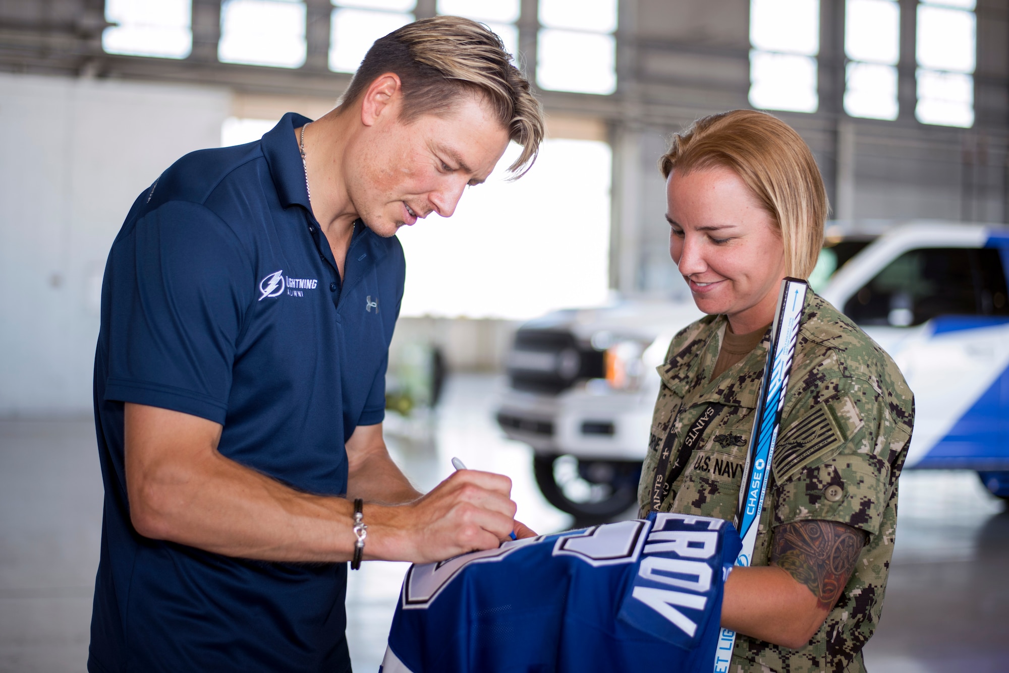 Former Tampa Bay Lightning player, Ruslan Fedotenko, signs a jersey for U.S. Navy Petty Officer 1st Class Taylor Horne, a leading petty officer assigned to Central Command’s Battle Damage Assessment team, at MacDill Air Force Base, Florida, Oct. 25, 2018.