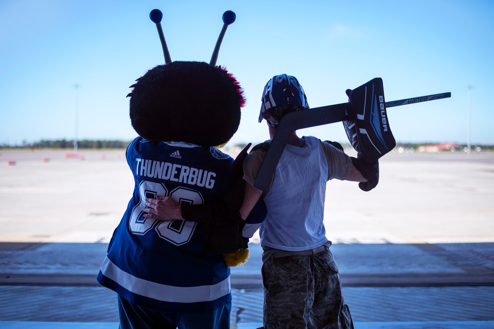 The Tampa Bay Lightning team mascot, the ThunderBug, looks over the flight line with an Airman at MacDill Air Force Base, Florida, Oct. 25, 2018.