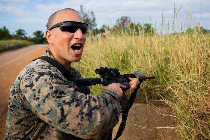 Sgt. Charles Flemister relays information to his squad during a fire and movement range Oct. 24, 2018, at Camp Hansen, Okinawa, Japan. During the range, Marines with 3rd Marine Logistics Group practiced their marksmanship skills, improved their communication and worked on their weapons handling while engaging targets. Flemister is a native of Los Angeles, California, and is a mortarman with the Tactical Readiness and Training, G-3, 3rd Marine Logistics Group Headquarters. (U.S. Marine Corps photo by Lance Cpl. Terry Wong)
